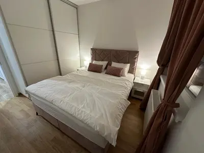 a bedroom with a bed with white sheets and pillows at Apartman Besta in Banja Luka