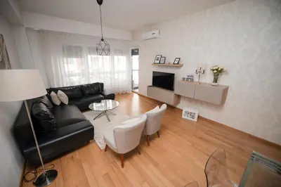 a living room with a couch and a table and chairs at City Museum 2 Apartments Banja Luka in Banja Luka