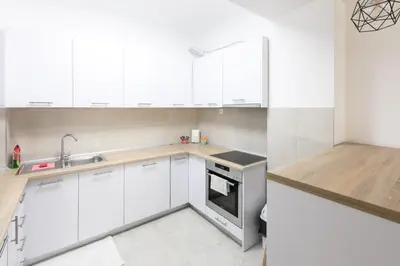a white kitchen with white cabinets and a sink at City Museum 2 Apartments Banja Luka in Banja Luka