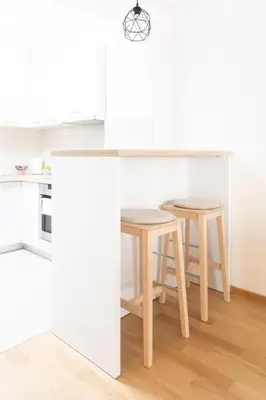 a kitchen with two tables and two stools at City Museum 2 Apartments Banja Luka in Banja Luka