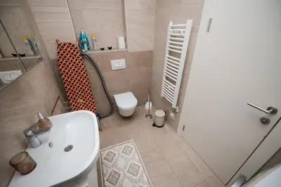 a bathroom with a white sink and a toilet at City Museum 2 Apartments Banja Luka in Banja Luka