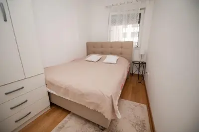 a white bedroom with a bed and a window at City Museum 2 Apartments Banja Luka in Banja Luka