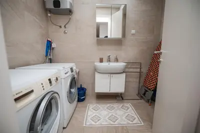 a bathroom with a washing machine and a sink at City Museum 2 Apartments Banja Luka in Banja Luka