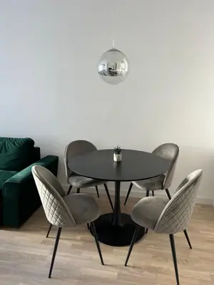 a table and chairs in a living room with a couch at D&ALux apartman in Banja Luka