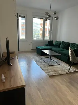 a living room with a green couch and a table at D&ALux apartman in Banja Luka