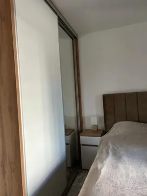 a small bedroom with a bed and a mirror at D&ALux apartman in Banja Luka