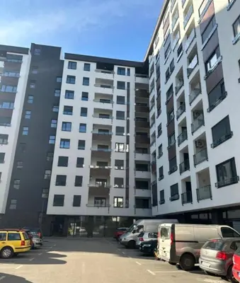 a large building with cars parked in a parking lot at D&ALux apartman in Banja Luka