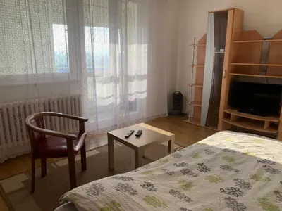 a bedroom with a bed and a chair and a table at Darija's place in Banja Luka