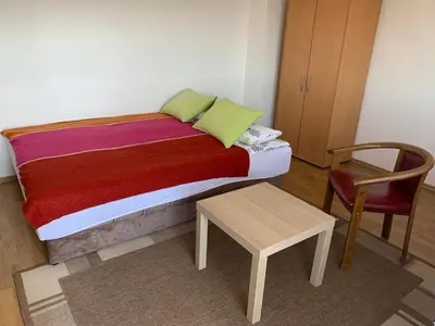 a bed in a room with a chair and a table at Darija's place in Banja Luka