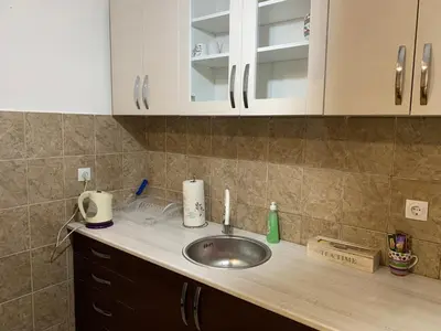 a kitchen counter with a sink and white cabinets at Darija's place in Banja Luka