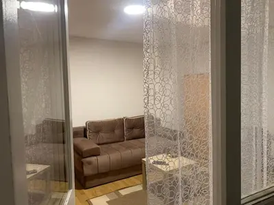 a living room with a couch and a glass door at Darija's place in Banja Luka