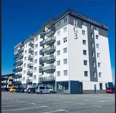 a large white building with cars parked in a parking lot at HG3 Jelah Stan na Dan in Jelah