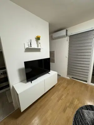 a white living room with a flat screen tv at Amina in Tuzla
