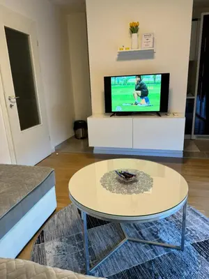 a living room with a coffee table and a tv at Amina in Tuzla