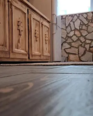 a room with wooden doors and a stone wall at Apartman Maximus in Kupres