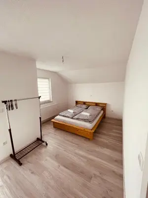 a bedroom with a bed and a refrigerator in it at Kuca za odmor Nedo in Kupres