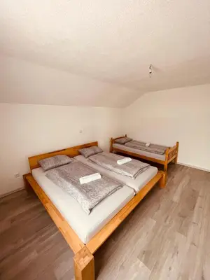 two twin beds in a room with wooden floors at Kuca za odmor Nedo in Kupres