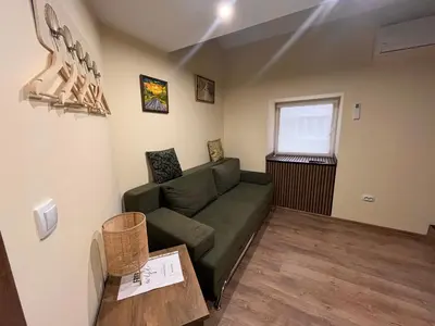a living room with a green couch and a table at Vila Dvorište in Banja Luka