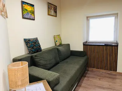 a living room with a green couch and a window at Vila Dvorište in Banja Luka