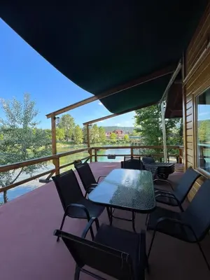 a patio with tables and chairs on a deck at Haus Palazzo in Bosanska Krupa