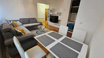 a living room with a couch and a table and chairs at Apartman Dolores in Banja Luka