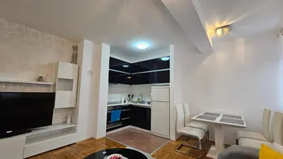 a small kitchen with a table and chairs in a room at Apartman Dolores in Banja Luka