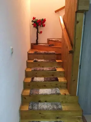 a wooden staircase with a vase of flowers on it at Apartman Lara in Kupres
