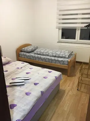 two beds sitting in a room with a window at Apartman Lara in Kupres