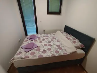 a bedroom with a bed with purple sheets and purple pillows at Apartman Lena Doboj in Doboj