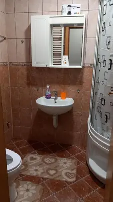 a bathroom with a sink and a shower and a toilet at Apartman Lena Doboj in Doboj