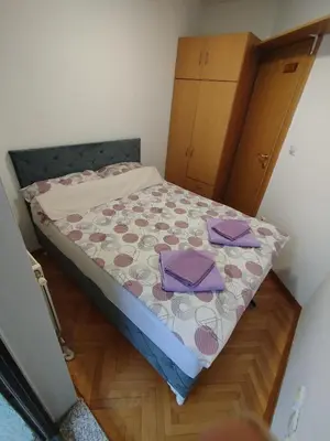 a small bedroom with a bed with purple sheets at Apartman Lena Doboj in Doboj