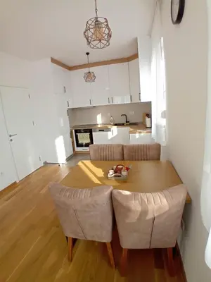 a kitchen and dining room with a table and chairs at Stan na dan Apartman ADA Banjaluka in Banja Luka