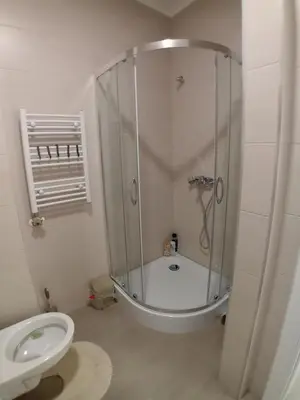 a white bathroom with a shower and a toilet at Stan na dan Apartman ADA Banjaluka in Banja Luka