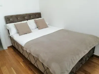 a large bed in a room with white walls at Stan na dan Apartman ADA Banjaluka in Banja Luka