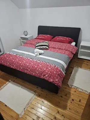 a bedroom with a bed with red pillows on it at Planinska kuća Ruža in Kupres