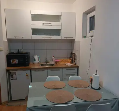 a kitchen with a table with chairs and a sink at Apartman Iva in Kupres
