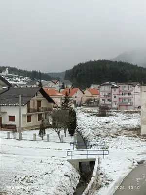 a snow covered town with buildings and a bridge at Apartman Iva in Kupres