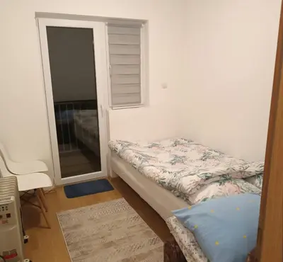 a small bedroom with a bed and a window at Apartman Iva in Kupres