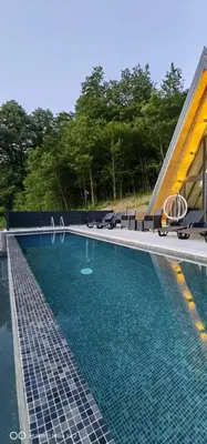 a swimming pool with chairs and a building at UNA RESORT in Bosanska Krupa