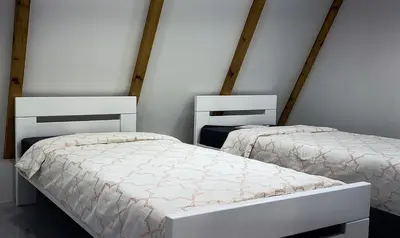 two beds in a room with white walls at UNA RESORT in Bosanska Krupa