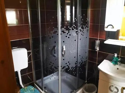 a shower with a glass door in a bathroom at Apartmani Šćit in Šćit