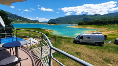 a camper van parked next to a lake at Apartmani Šćit in Šćit