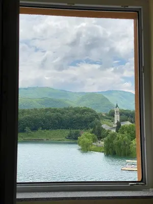 a window with a view of a lake and a church at Apartmani Šćit in Šćit