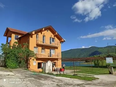 a large house with mountains in the background at Apartmani Šćit in Šćit