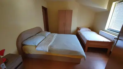 a small bedroom with two beds and a window at Apartmani Šćit in Šćit