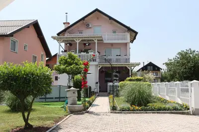 a pink house with a white fence and flowers at Holiday Home Peaceful Retreat in Visoko