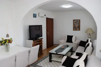 a living room with white furniture and a tv at Holiday Home Peaceful Retreat in Visoko