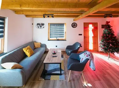 a living room with a couch and a christmas tree at Jerry's Cottage Banja Luka in Banja Luka