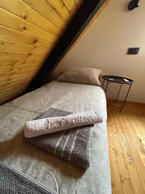 a bed in a room with a wooden ceiling at Jerry's Cottage Banja Luka in Banja Luka