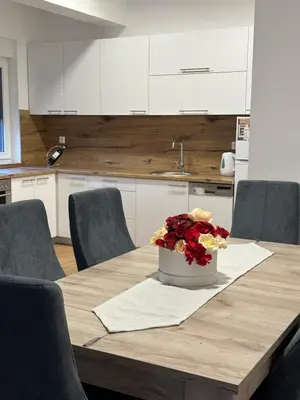 a dining room table with a vase of flowers on it at Restoran&Motel and apartmants Lovacka prica in Tešanj